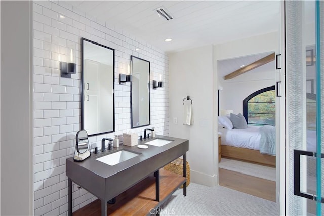 bathroom featuring decorative backsplash, tile patterned flooring, vanity, and tile walls