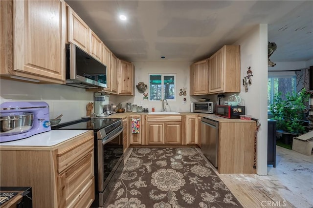 kitchen featuring sink, light brown cabinetry, and stainless steel appliances