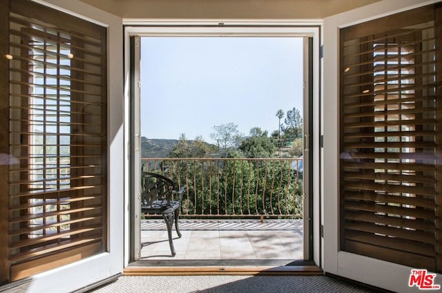 doorway to outside featuring carpet and a wealth of natural light