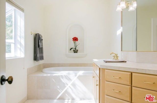 bathroom with vanity, tile patterned flooring, and tiled bath