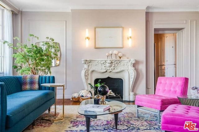 sitting room featuring a fireplace, wood-type flooring, and ornamental molding