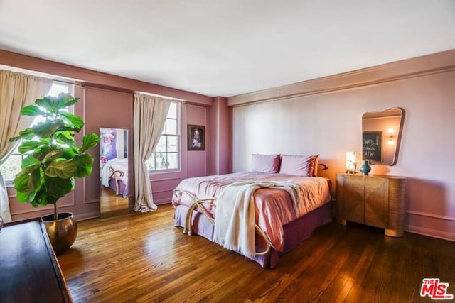 bedroom with dark hardwood / wood-style floors