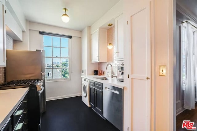 kitchen featuring appliances with stainless steel finishes, sink, washer / clothes dryer, decorative light fixtures, and white cabinetry