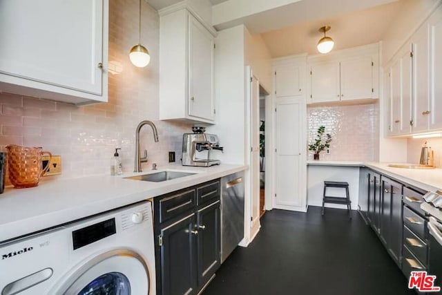 kitchen with pendant lighting, washer / dryer, sink, tasteful backsplash, and white cabinetry