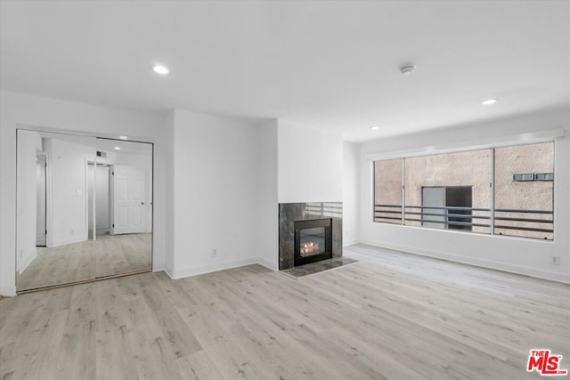 unfurnished living room featuring light hardwood / wood-style flooring and a fireplace