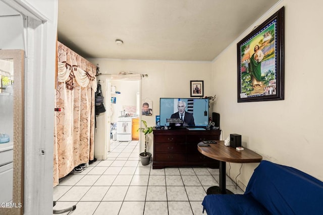 bedroom with washer / clothes dryer, crown molding, and light tile patterned floors