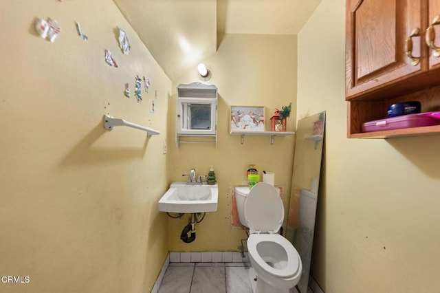 bathroom featuring sink, toilet, and tile patterned flooring