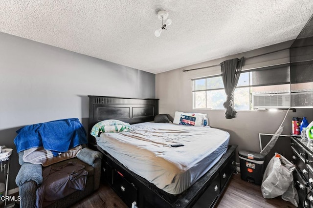 bedroom featuring hardwood / wood-style floors, a textured ceiling, and cooling unit