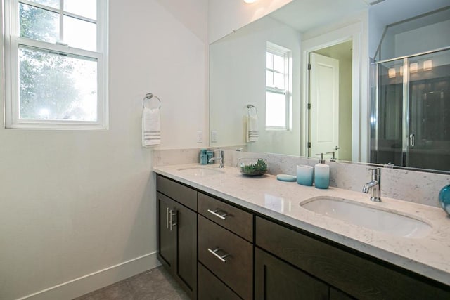 bathroom featuring tile patterned floors, vanity, and a shower with shower door