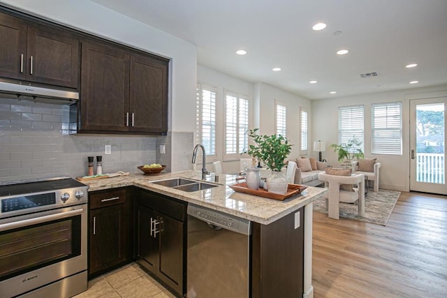 kitchen featuring sink, dark brown cabinets, kitchen peninsula, and appliances with stainless steel finishes