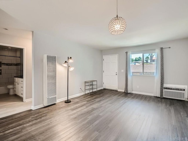 spare room with dark wood-type flooring and a wall unit AC