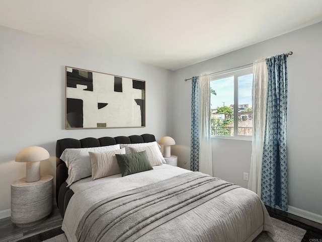 bedroom with baseboards and wood finished floors