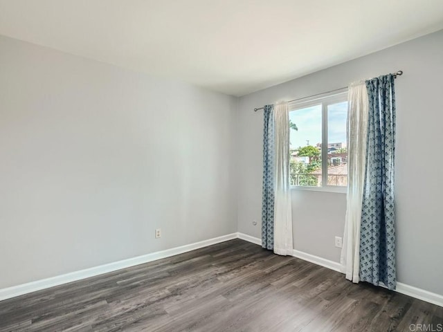 unfurnished room featuring dark wood finished floors and baseboards