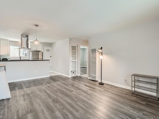 unfurnished living room with baseboards and wood finished floors