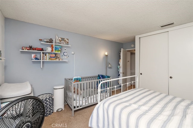 carpeted bedroom with a closet and a textured ceiling