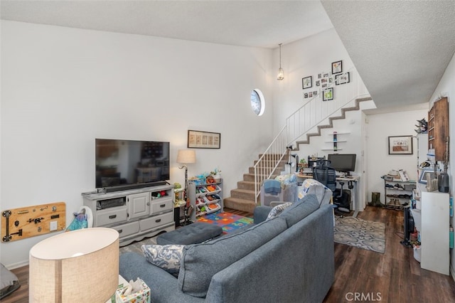 living room featuring dark wood-type flooring and a textured ceiling