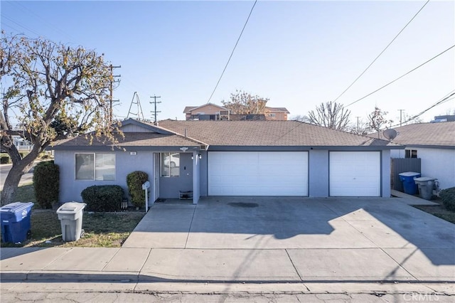 ranch-style home with driveway, an attached garage, and stucco siding