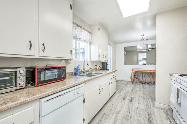 kitchen featuring white appliances, a sink, white cabinets, light wood-style flooring, and light countertops