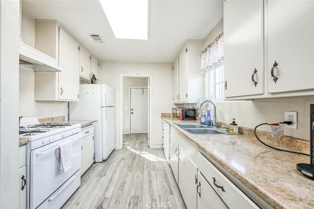 kitchen with white appliances, a sink, light wood-style floors, light countertops, and white cabinets
