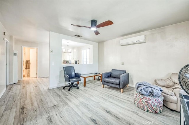 living area with a wall mounted AC, wood finished floors, ceiling fan, and baseboards
