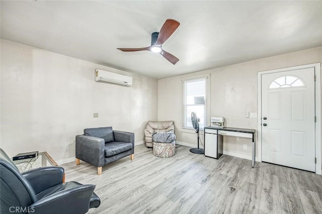 living area featuring a wall mounted AC, wood finished floors, ceiling fan, and baseboards
