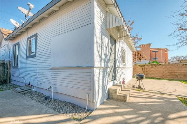 view of property exterior featuring fence and a patio area