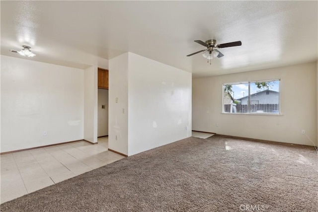 unfurnished room featuring light colored carpet, ceiling fan, and baseboards