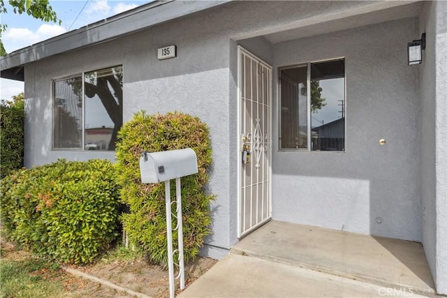 property entrance featuring stucco siding