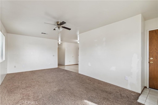 empty room featuring ceiling fan and light colored carpet