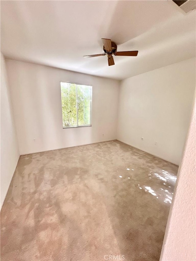 carpeted spare room with ceiling fan