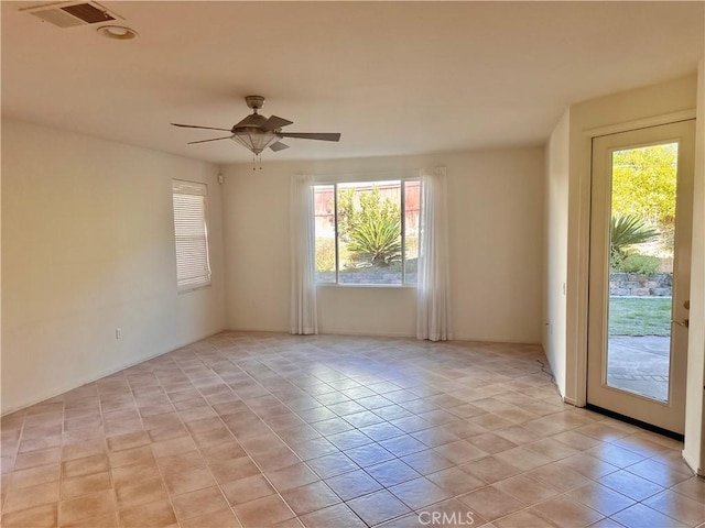 tiled spare room featuring ceiling fan