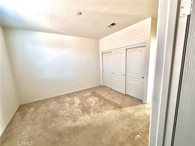 unfurnished bedroom featuring a closet and light carpet