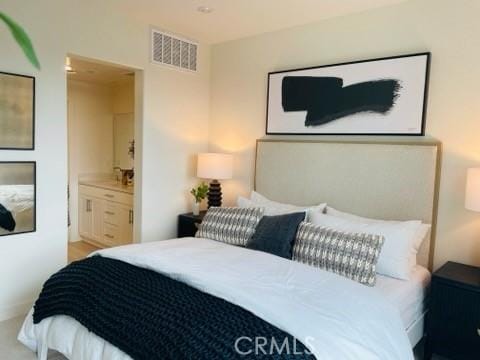 bedroom featuring visible vents and connected bathroom