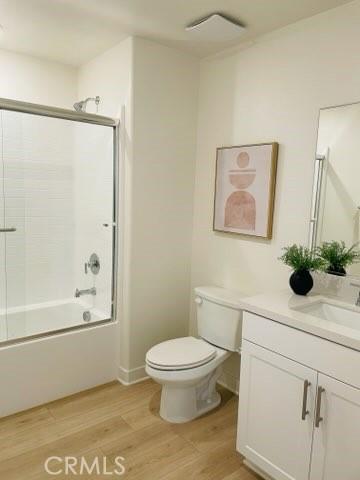 1810 E 1st St E Unit 100, Santa Ana, CA 92705 - bathroom featuring vanity, toilet, wood finished floors, and enclosed tub / shower combo