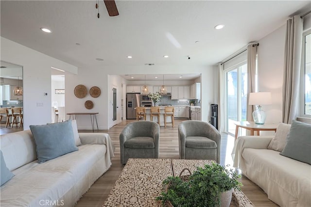 living room featuring light hardwood / wood-style flooring and ceiling fan