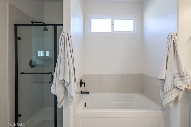 bathroom featuring shower with separate bathtub