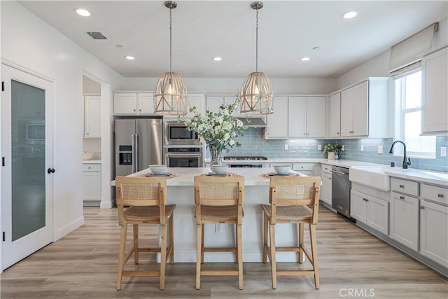 kitchen with sink, white cabinets, a center island, and appliances with stainless steel finishes