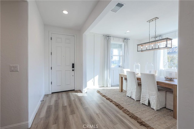 unfurnished dining area with light hardwood / wood-style flooring and a notable chandelier