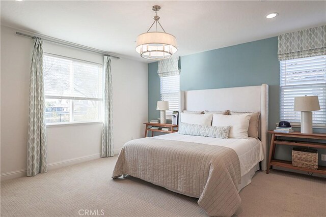 bedroom featuring light carpet and multiple windows