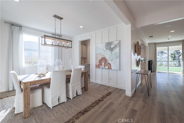 dining space featuring wood-type flooring and a chandelier