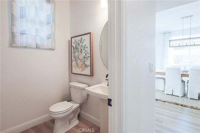 bathroom featuring hardwood / wood-style flooring and toilet