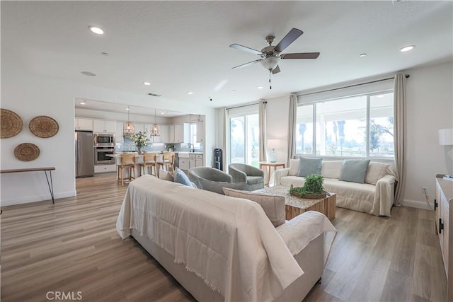 living room featuring light wood-type flooring and ceiling fan