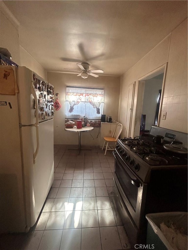 kitchen with white fridge, stainless steel gas range, and ceiling fan