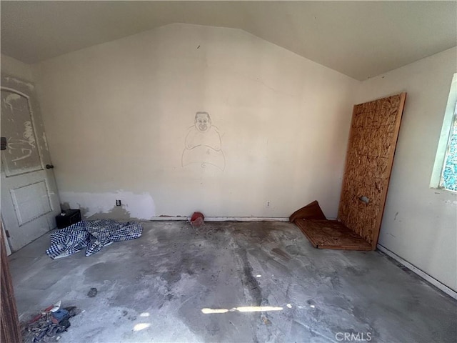 interior space featuring lofted ceiling and concrete floors