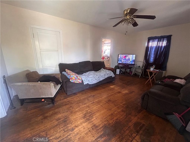 living room featuring dark hardwood / wood-style flooring and ceiling fan