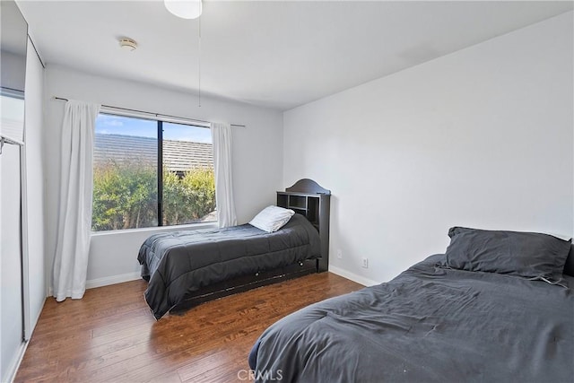 bedroom with multiple windows and hardwood / wood-style flooring