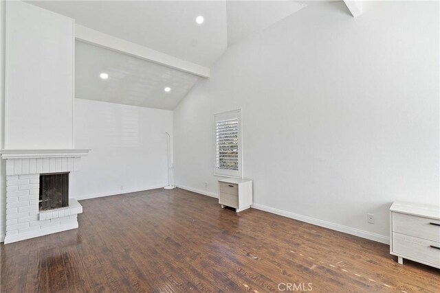 unfurnished living room featuring a fireplace, beam ceiling, high vaulted ceiling, and dark hardwood / wood-style flooring