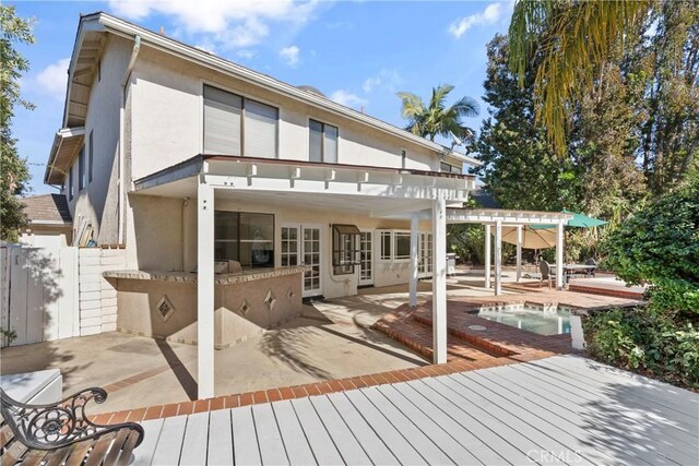 rear view of house featuring a patio, a pool side deck, and a pergola