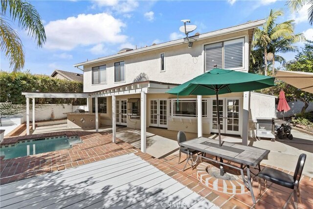 back of house with a swimming pool side deck, a patio, and french doors