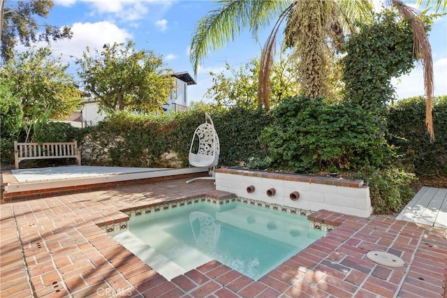 view of pool with a patio area and a hot tub